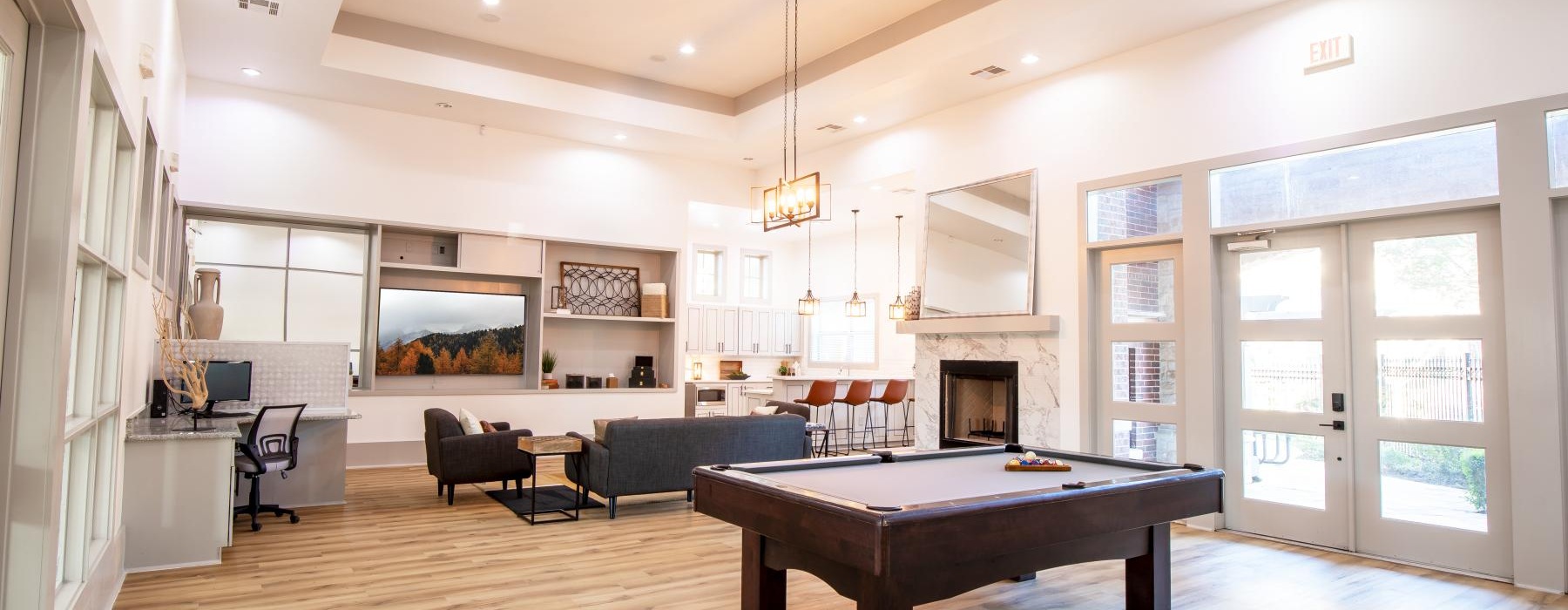 a lounge with a wood floor pool table and tv