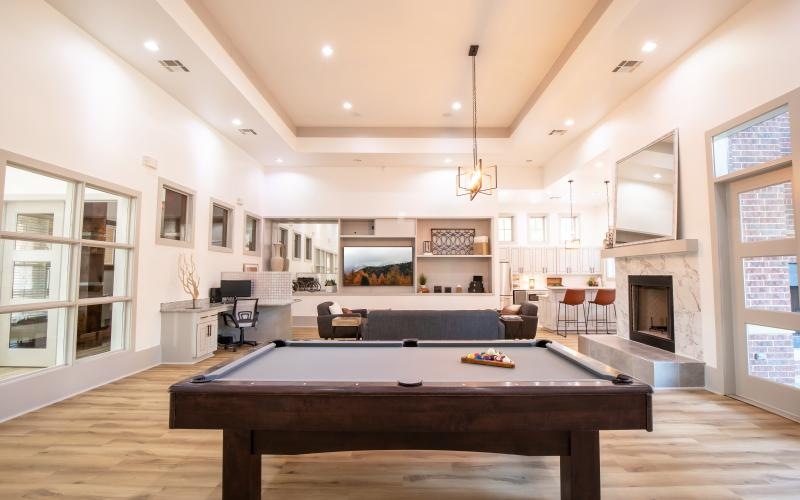 a large room with a pool table and chairs